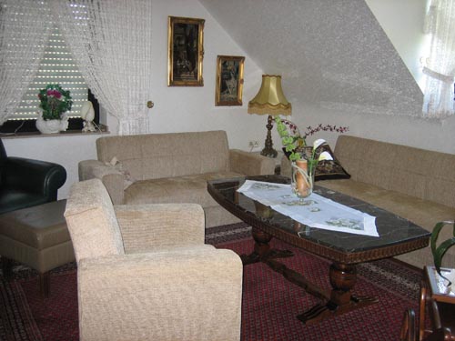 Helles Wohnzimmer der Ferienwohnung Gisbertz mit Echtholzparkett, Blick von der Diele